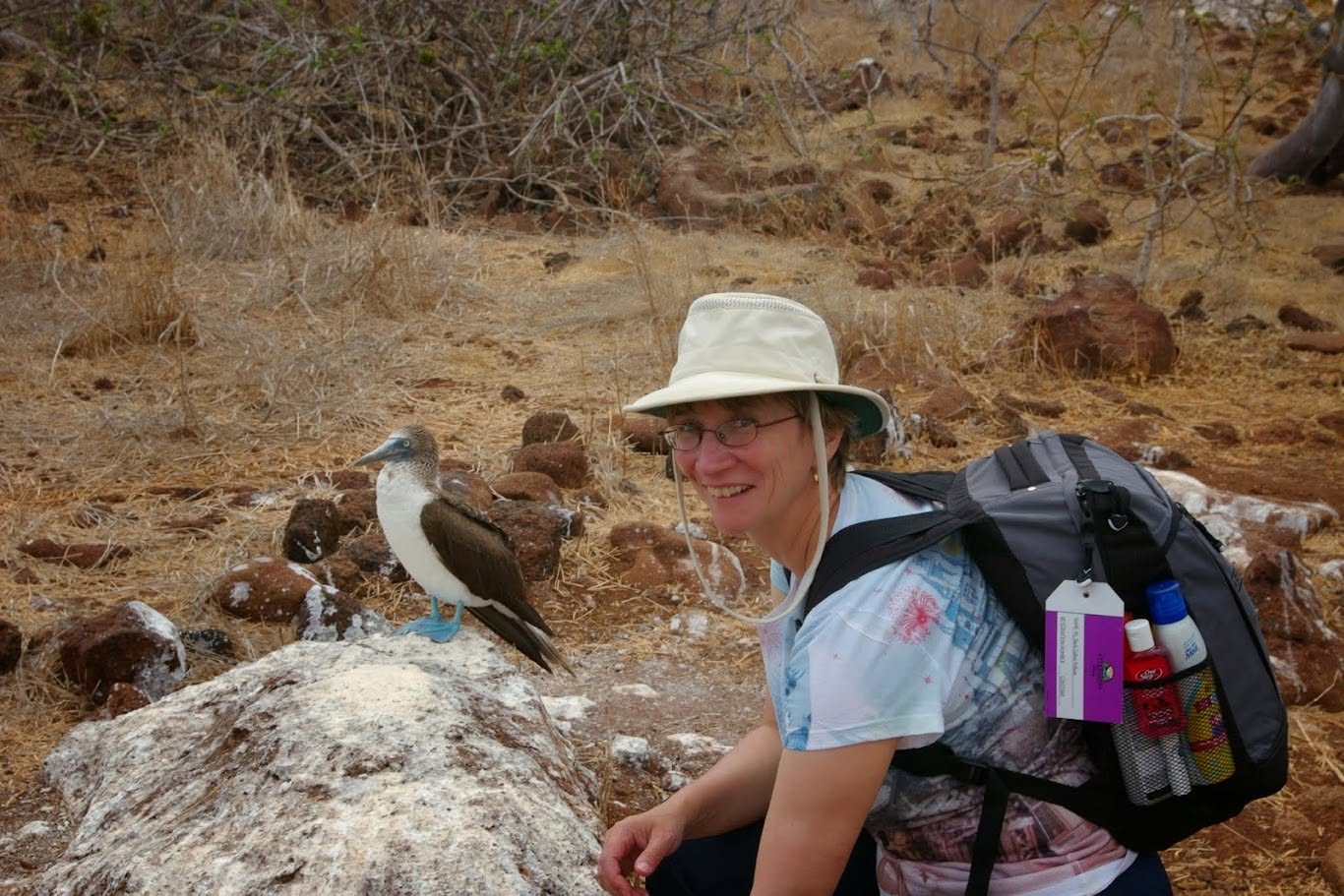 Sheila Gallant-Halloran in Galapagos off an expedition cruise, with a blue-footed booby.