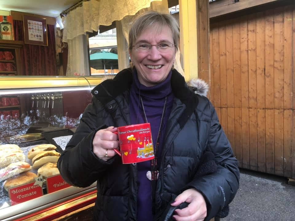 Sheila Gallant-Halloran holding a cup of Glühwein at a Christmas market in Vienna, Austria